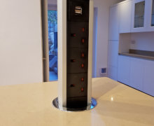 White handleless kitchen with oatmeal quartz worktops pop up electrical socket