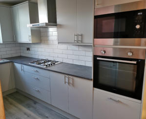 light grey Howdens kitchen with compact laminate worktops in Stockport