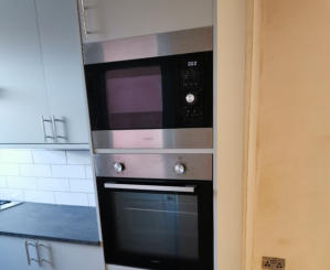 light grey Howdens kitchen with compact laminate worktops in Stockport