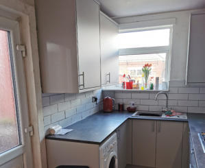 light grey Howdens kitchen with compact laminate worktops in Stockport