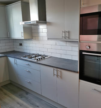 light grey Howdens kitchen with compact laminate worktops in Stockport