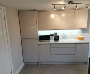 light grey handleless kitchen in Heald Green. Installed with grey quartz worktops