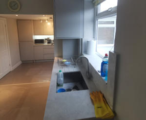 light grey handleless kitchen in Heald Green. Installed with grey quartz worktops