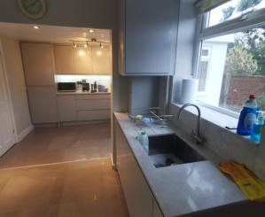 light grey handleless kitchen in Heald Green. Installed with grey quartz worktops