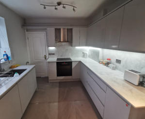 light grey handleless kitchen in Heald Green. Installed with grey quartz worktops