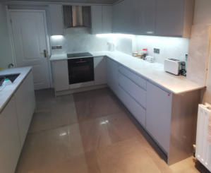 light grey handleless kitchen in Heald Green. Installed with grey quartz worktops