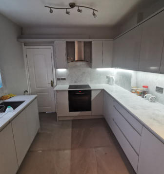 light grey handleless kitchen in Heald Green. Installed with grey quartz worktops