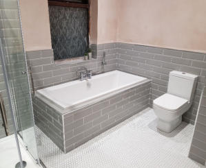 New bathroom in Bramhall. Grey metro wall tiles and small white hexagon floor tiles