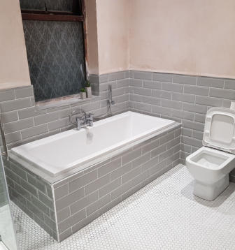 New bathroom in Bramhall. Grey metro wall tiles and small white hexagon floor tiles