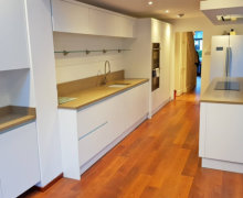 white handleless kitchen with quartz worktops and oak flooring