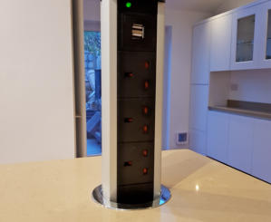 White handleless kitchen with oatmeal quartz worktops pop up electrical socket